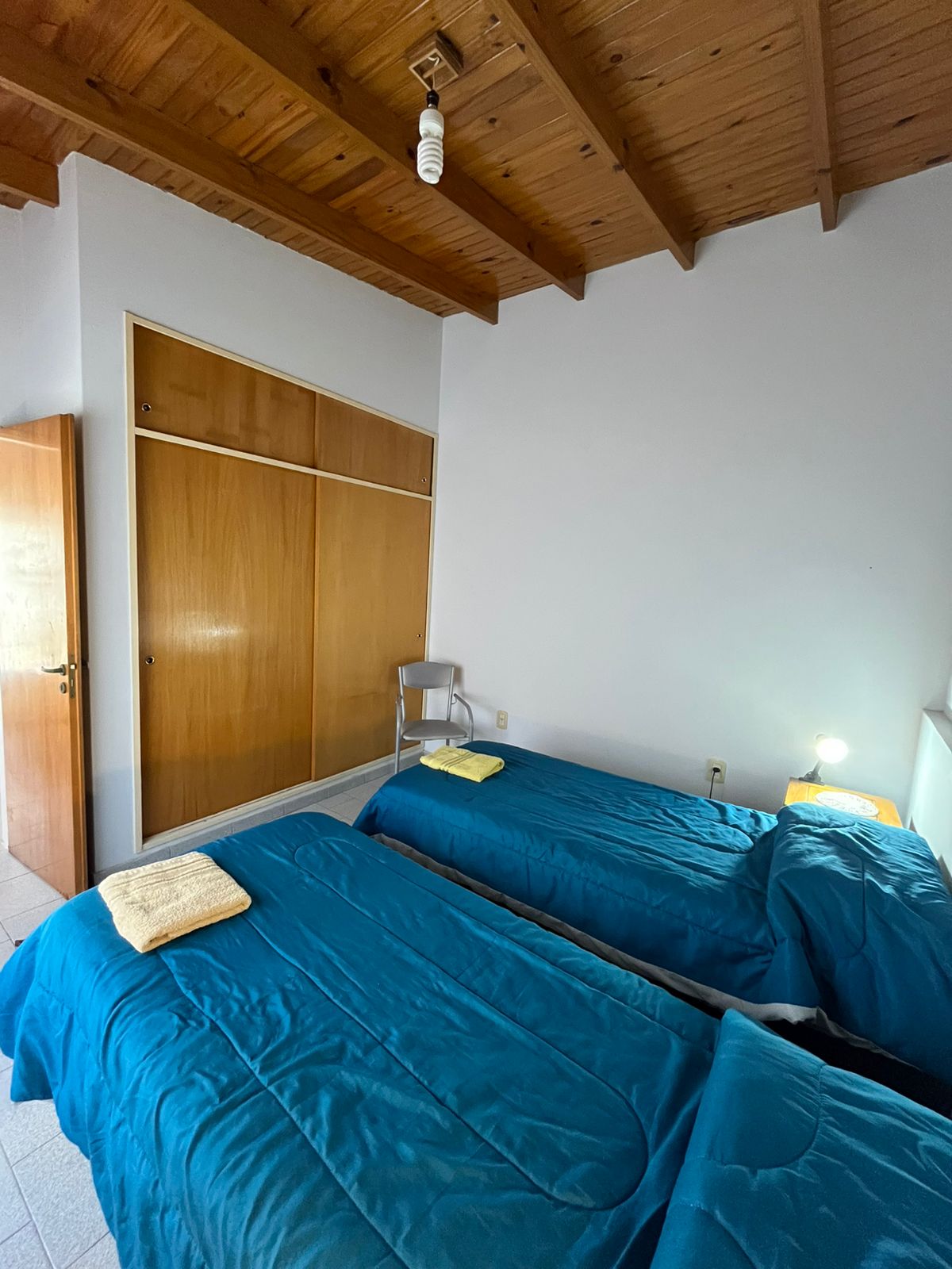 Habitación con dos camas y techo de vigas de madera
