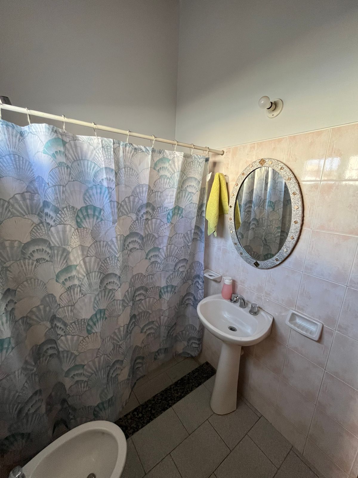 Baño con ducha y espejo decorativo